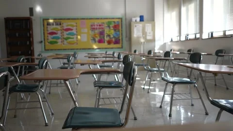 Desks in empty dark high, middle, or elementary school classroom with light Stock Footage 167619365