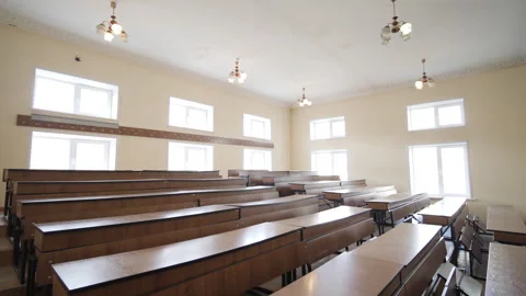 Desks In Empty Lecture Hall Classroom Against Bright Windows Stock Footage 277340178