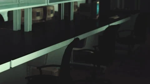 Desks with old computers and empty chairs in a dark room Stock Footage 342039963