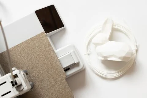Desktop 3D printer and white low-poly rabbit and filament on white backgrou.. Stock Photos