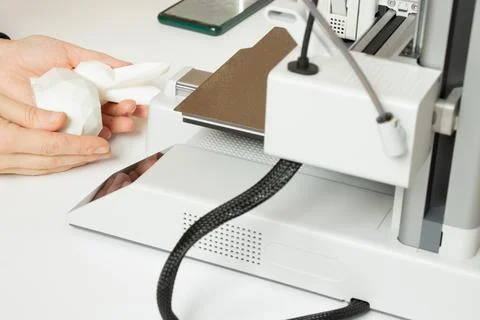 A desktop 3D printer and a white low-poly bunny on the printer, along with .. Stock Photos