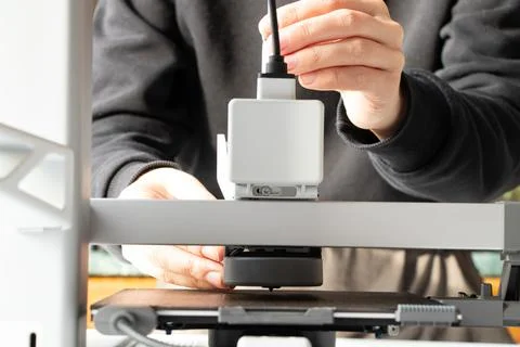 A desktop 3D printer and a woman's hands, modern technologies for additive .. Stock Photos