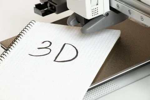Desktop 3D printer on white background and notebook with 3D inscription, ad.. Stock Photos