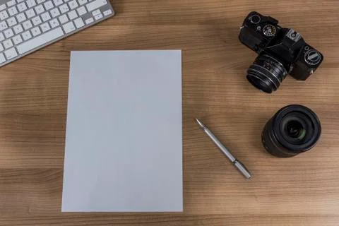 Desktop with camera and blank sheet Stock Photos