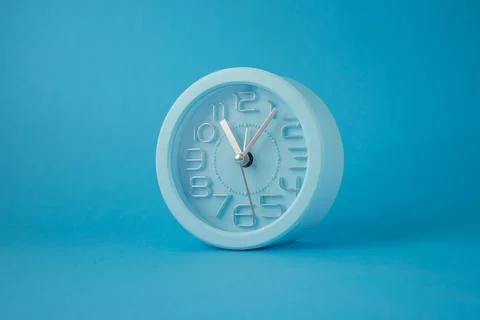 Desktop classic clock alarm clock isolated on blue background Illustration