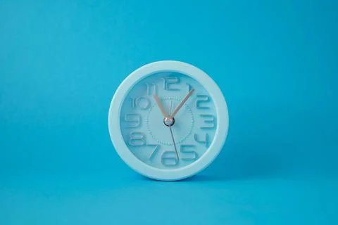 Desktop classic clock alarm clock isolated on blue background Illustration