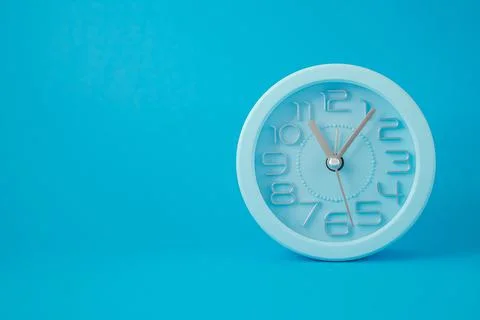 Desktop classic clock alarm clock isolated on blue background Illustration