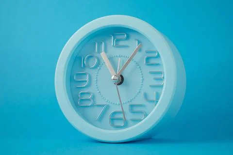 Desktop classic clock alarm clock isolated on blue background Stock Photos