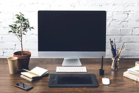 Desktop computer with blank screen and digital devices at designer workplace Stock Photos