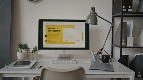 Desktop Computer Displaying Financial Highlights on Office Desk Stock Footage 345239125