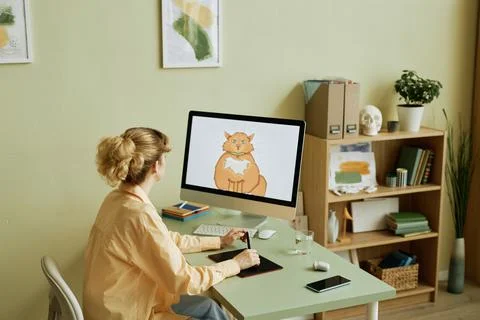 Desktop computer with fat ginger cat drawn by girl on screen Stock Photos
