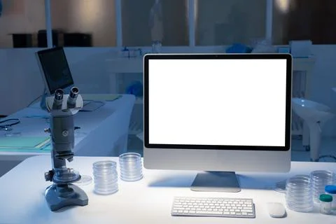 Desktop computer with illuminated screen at workstation in medical laboratory Foto stock