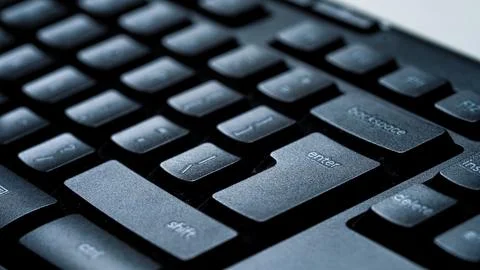 Desktop computer keyboard with light shining on keys. Stockfoto's