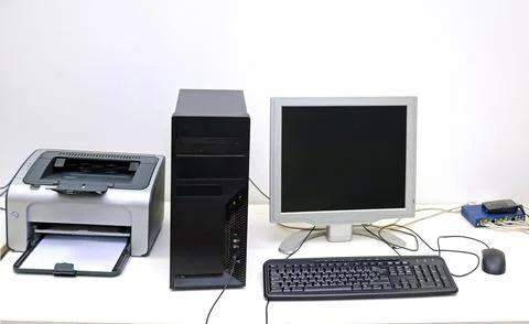 Desktop computer screen and keyboard with printer inside office interior Stock Photos