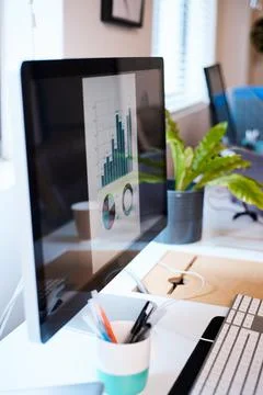 A desktop computer screen with a bar graph and pie chart in blue Stock Photos