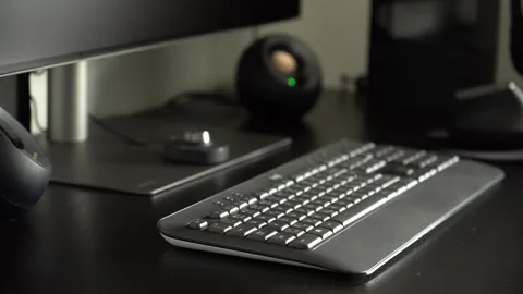 A desktop computer setup on an office table - speakers and a keyboard - closeup Stock Footage 246316646