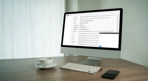 Desktop computer showing email inbox on screen with keyboard smartphone and.. Stock Photos