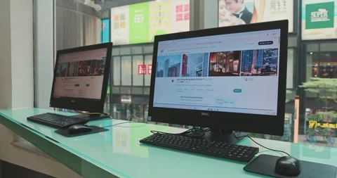 Desktop computers displaying web pages by urban window setting Stock Footage 344460447