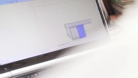 A desktop display from behind the architect's back. Drawing a kitchen in a Stock Footage 127512296