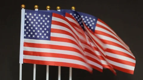 Desktop flags of USA flutter on black background. Concept of the patriotic ho 스톡 동영상 129084924