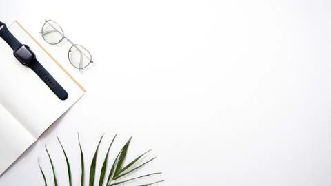 Desktop flat lay. Notepad, watches, glasses and palm on a white background. Stock Photos