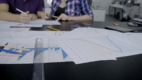 On desktop is a helmet, documents with graphs, with which people work. Video stock 88465000