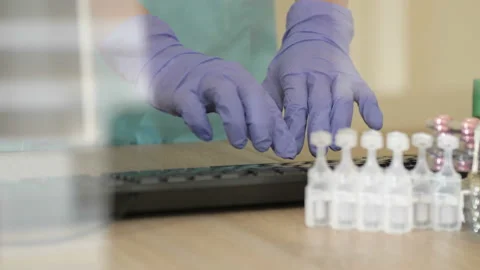 Desktop of a medical worker. Computer keyboard, medication. The doctor s hands 動画素材 127382201