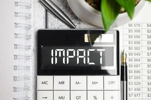 On the desktop there are reports, a white calculator with the text IMPACT o.. 写真素材