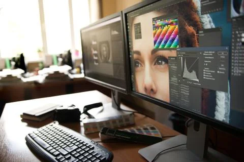Desktop with two monitors, a keyboard, a camera, a diary, a palette for a des Stock Photos