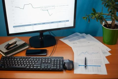 Desktop on which the printed chart is next to the keyboard and the daily on t Stock Photos