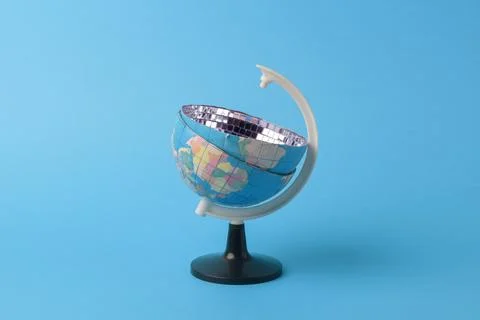 Desktop world globe with mirror disco bowl top on blue background, playful Stock Photos