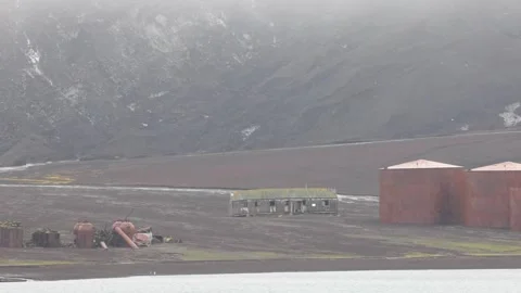 Desolate Abandoned Antarctic Outpost Under Misty Volcanic Mountain Video stock 345137195