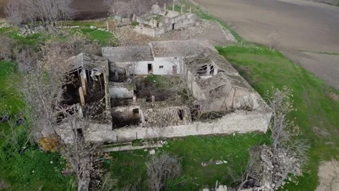 A desolate, abandoned building sits in a field. aerial view, drone photograph Stock Footage 303773339
