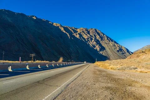 Desolate asphalt thoroughfare cuts through mountainous natural landscape Foto stock