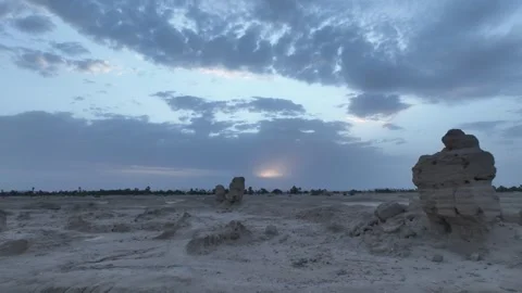 Desolate Barren Desert Landscape with Eroded Mud Formations under Cloudy Stock Footage 345685988