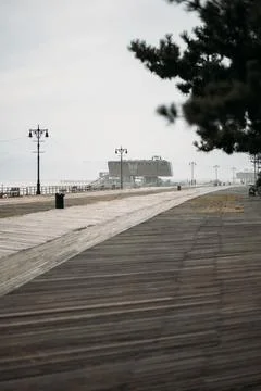 Desolate Boardwalk Leading to a Distant Building in New York Stock Photos