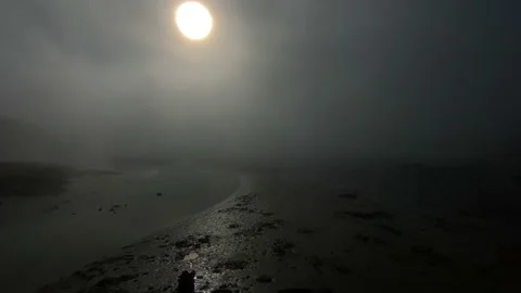 Desolate dramatic mudflat in heavy mist with obscured sun Stock Footage 144433315
