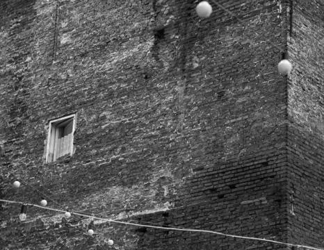 The desolate lonely old window at the corner of the house Stock Photos