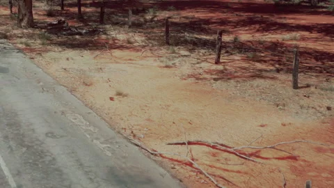 Desolate Road Through Red Earth Landscape Under a Bright Sky Video stock 347256703