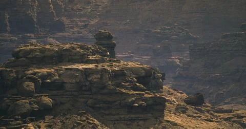 Desolate rocky landscape under dramatic sunlight in a remote location Illustrazione stock