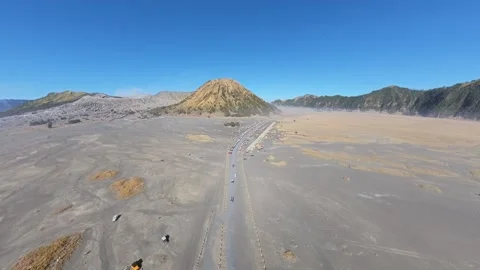 Desolate volcanic plain stretches under bright blue sky Stock Footage 346912485