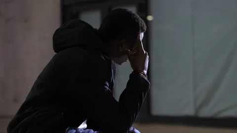 Despair, anguish - sad depressed black man in the city at night thinking Stock Footage 154181160