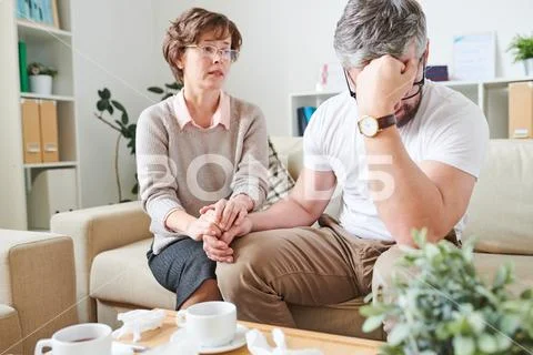 Despaired man coping with emotions at therapy session Stock Photos