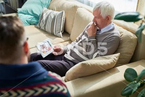 Despaired man sharing his family problems with psychiatrist Stock Photos