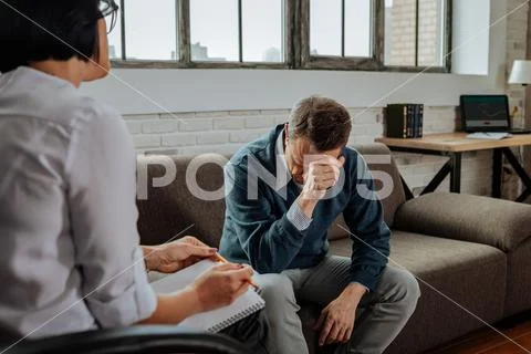 Despaired short-haired patient having mental issues and explaining them Stock Photos