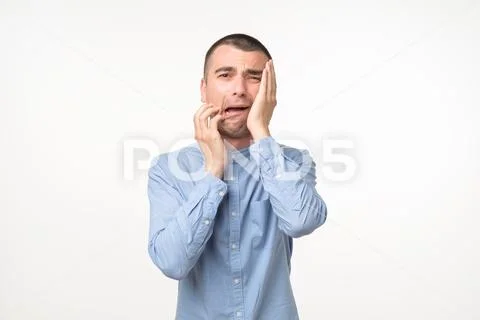 Despaired spanish man in blue shirt is crying. Stock Photos