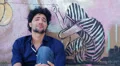 desperate and depressed young man sitting near a graffiti wall HD Footage