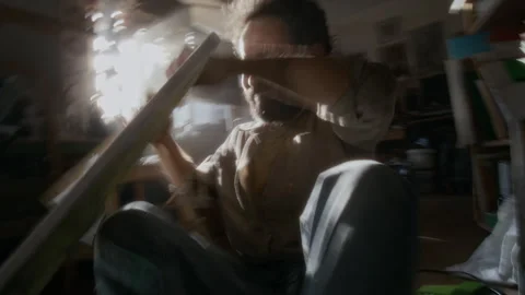 Desperate Artist Ripping Canvas during Creative Struggle in Sunlit Studio Stock Footage 334684149