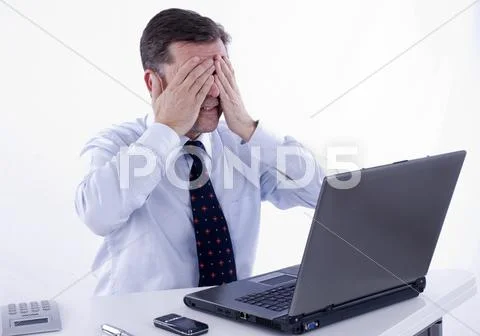 Desperate businessman, over 50, working on a laptop Stock Photos