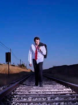 Desperate man, dressed in a suit, on train tracks Stock Photos